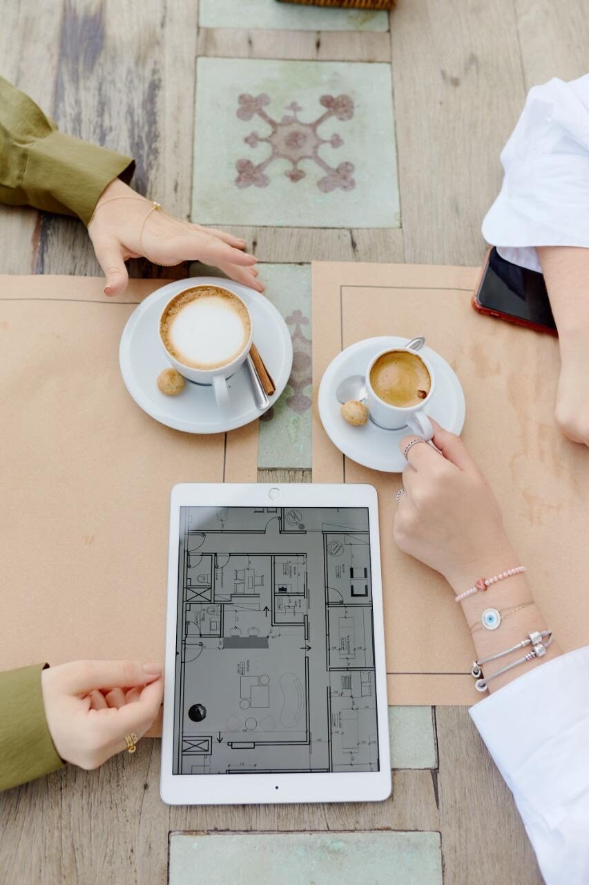 Flatlay de reunião com café e projeto em tablet